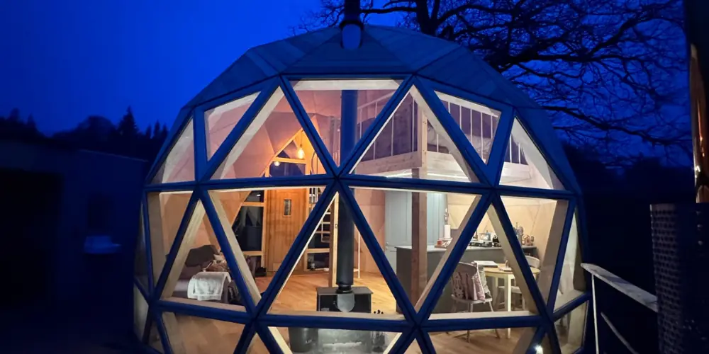 The Nova Dome glowing at blue hour, its triangular panels lit from inside