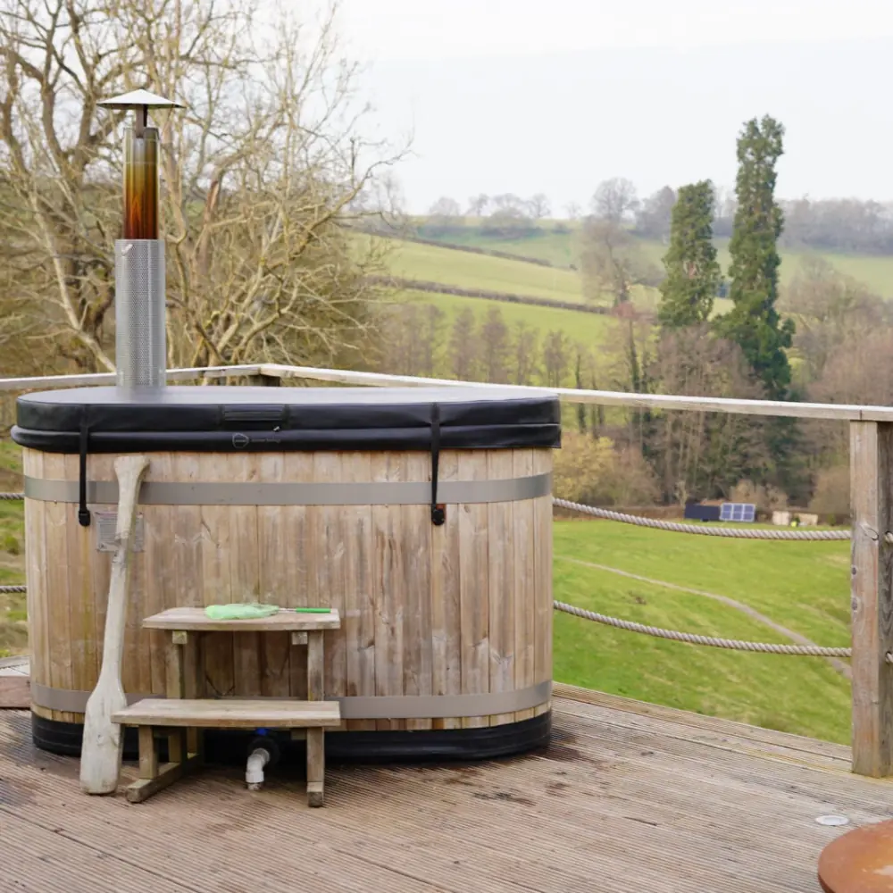 Wooden hot tub on the Nova Dome deck overlooking fields