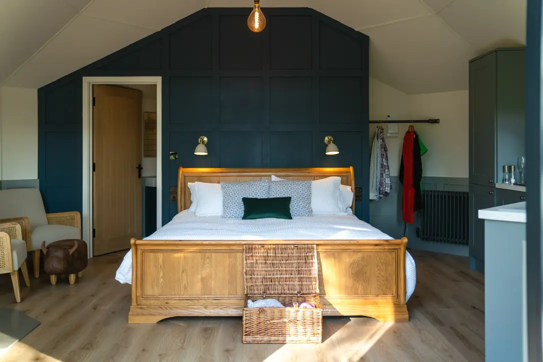 The Treehouse bedroom with a wooden super king bed and dark panelled walls